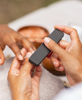 Woman using a buffer to file nail